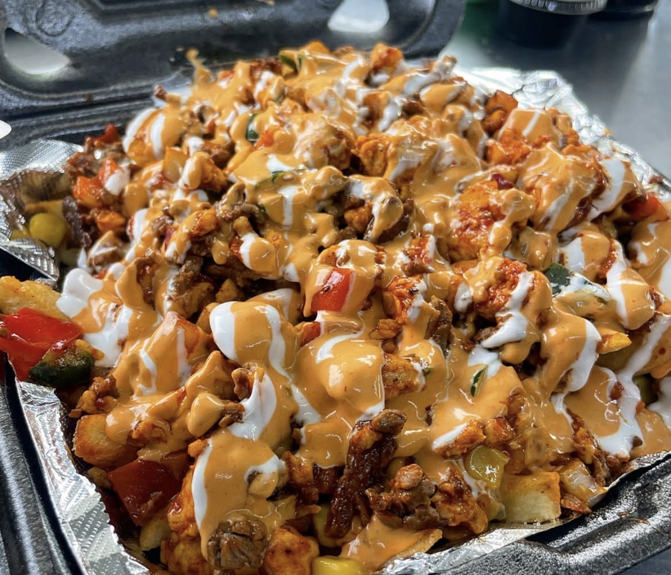 Loaded fries with meat, vegetables and creamy sauces